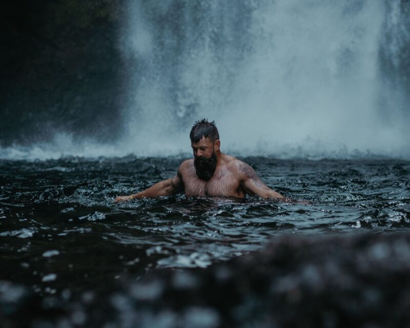 Mann badet in einem kalten Fluss